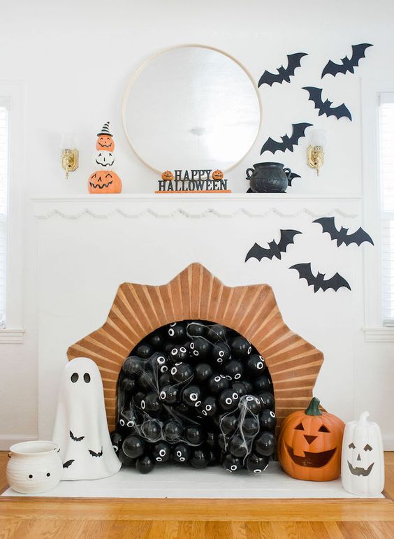 Stylish and fun Halloween decor with black balloons in the fireplace, black bats, ghosts, jack o lanterns and pumpkins