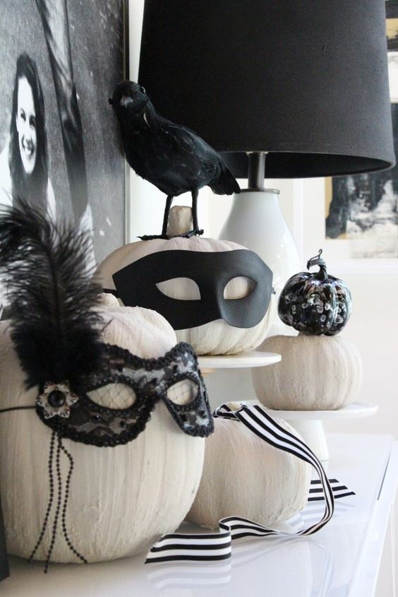white pumpkins with chic decor - black embellished masks and feathers are amazing for Halloween and are very easy to make