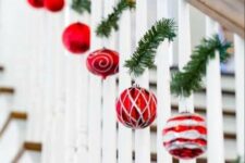 a banister decorated with evergreens and red and silver ornaments is a beautiful idea for Christmas