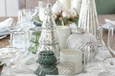 a beautiful Christmas tablescape with mercury glass trees and candleholders, metallic ornaments and evergreens