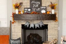 a bold Thanksgiving mantel with lots of dried leaves, wheat, pumpkins of various materials, garlands and several signs