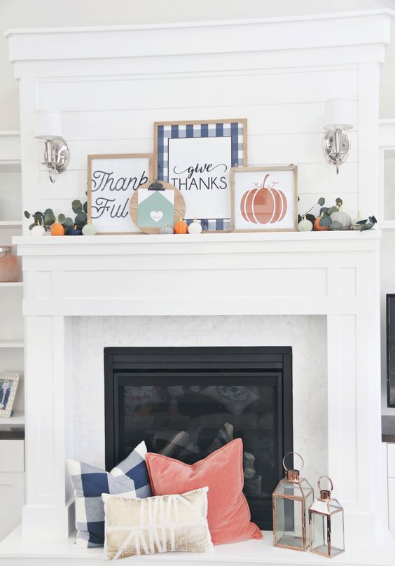 a bright Thanksgiving mantel with bold signs, greenery and mini pumpkins and matching pillows at the fireplace