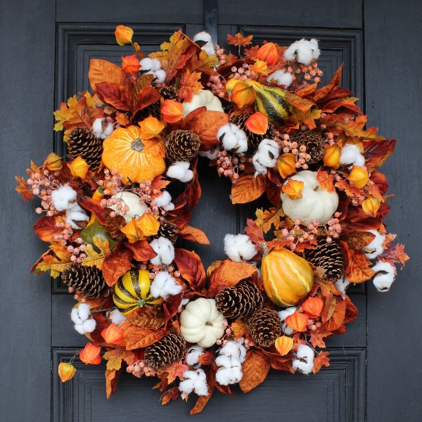 A bright Thanksgiving wreath with pinecones, gourds, pumpkins, leaves and dried blooms is a very eye catchy solution