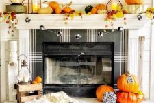 a bright and fun Thanksgiving mantel with bold pumpkins, bright leaves, candle lanterns and a plaid ball garland