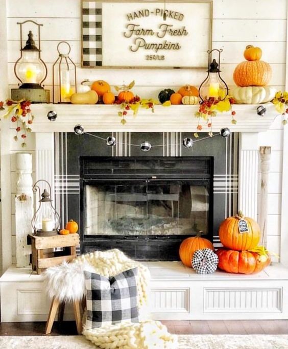 a bright and fun Thanksgiving mantel with bold pumpkins, bright leaves, candle lanterns and a plaid ball garland