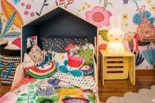 a bright and fun kid’s room with a floral wall, matching floral bedding, fruit and flower pillows and a Miffy lamp