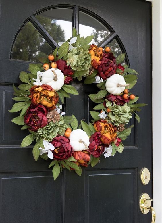 a bright fall or Thanksgiving wreath of leaves, white gourds and bold faux blooms is a stylish and timeless decoration