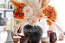 a bright modern Thanksgiving centerpiece of orange and blush blooms and dried grasses is a gorgeous idea for your party