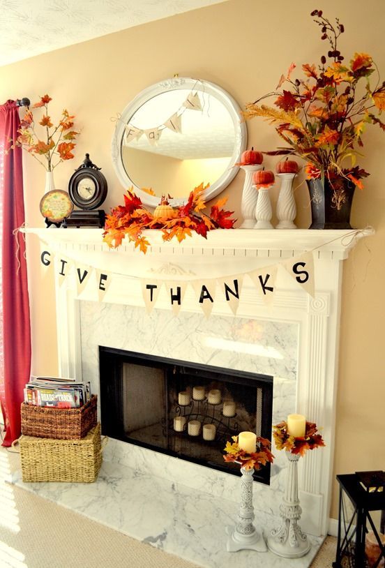 a bright rustic Thanksgiving mantel with bold leaf arrangements, pumpkins on stands, some banners and candles in candleholders