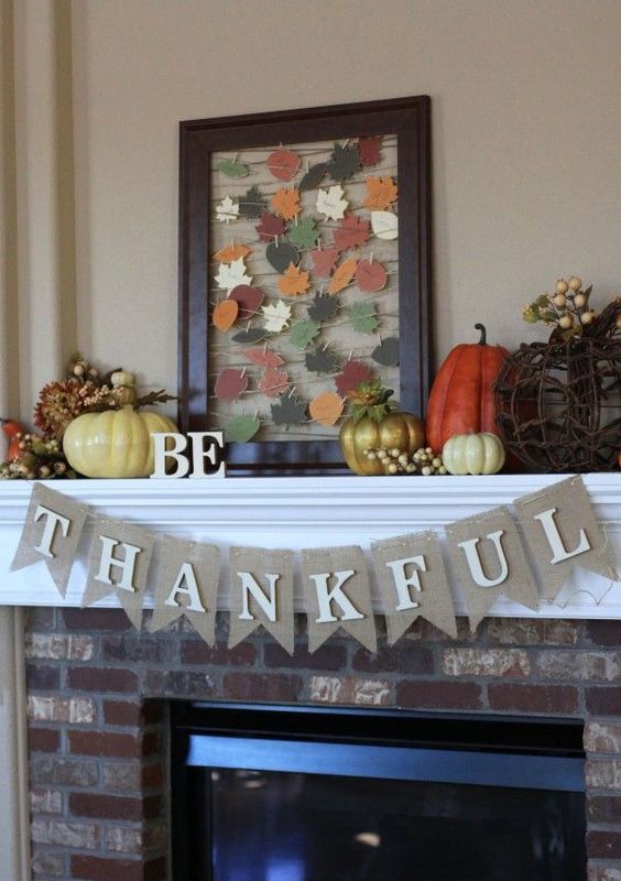 a bright vintage Thanksgiving mantel with bold pumpkins, berries, and string art with colorful paper leaves