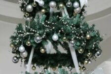 a chandelier made of faux evergreen wreaths and silver and gold ornaments is a gorgeous Christmas decoration