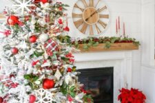 a chic farmhouse Christmas tree with red and white ornaments, a plaid ribbon, snowflakes and foliage plus berries is wow