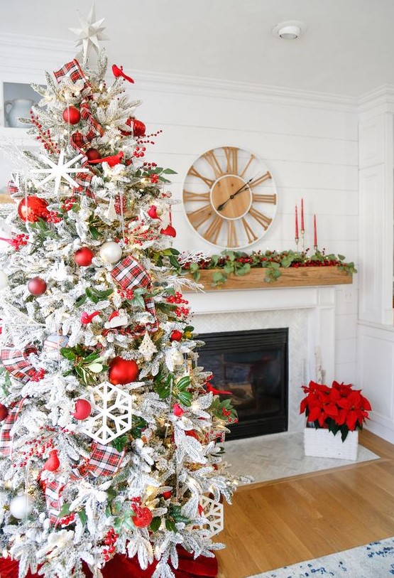 a chic farmhouse Christmas tree with red and white ornaments, a plaid ribbon, snowflakes and foliage plus berries is wow