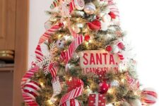a colorful Christmas tree decorated with striped and silver ornaments, ribbons, candy ornaments and berries is fun