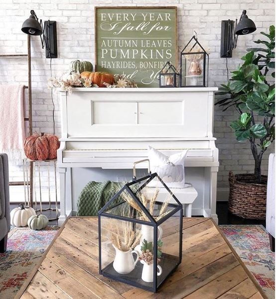 a fall or Thanksgiving mantel with heirloom pumpkins, paper leaves and blooms, lanterns with wheat and some signs