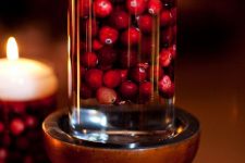 a glass with cranberries and a floating candle on top will make your Thanksgiving or Christmas cooler and cozier