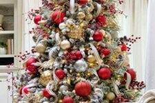 a gorgeous Christmas tree with gold, red and clear ornaments, berry branches, twigs and ribbons