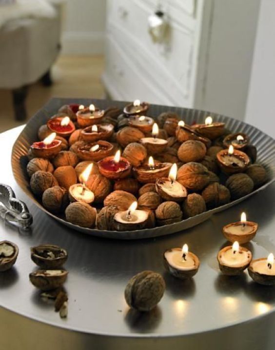 a metal dish with walnuts and tiny walnut shell candles is a cool rustic centerpiece for the fall and not only