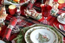 a plaid tablecloth and napkins add a cozy traditional feel to the table, and evergreens make it lively