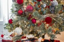 a pretty and bold Christmas tree decorated with glossy red, red velvet, red plaid ornaments and greenery plus matching gift boxes under the tree