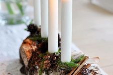 a pretty woodland candelabra of a tree stump, evergreens and cinnamon and some candles is a gorgeous idea for both fall and winter decor