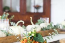 a rustic Thanksgiving place setting with a woven placemat, a printed napkin, a white pumpkin with blooms and greenery