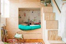 a small shared kids’ space with a plywood bunk bed with colorful bedding, a printed rug, a bookshelf and a basket with toys