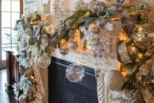 a sophisticated Christmas mantel with clear and silver glitter ornaments, snowy leaves and ribbons, white branches and lights