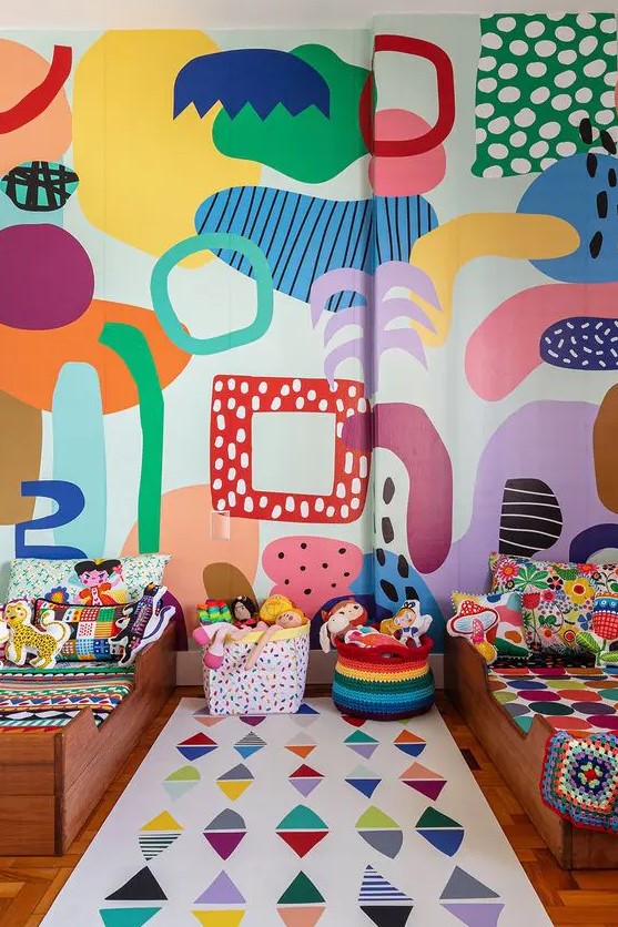 a super colorful shared kid's bedroom with a bold abstract wall, colorful linens and baskets, bold toys