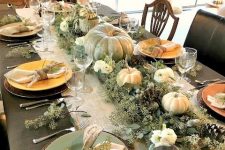 a woodland or rustic Thanksgiving centerpiece of greenery, pinecones, green and white pumpkins plus blooms