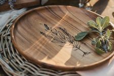 a woven placemat and a wooden plate with wood burning for a lovely farmhouse-inspired Thanksgiving tablescape