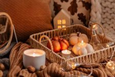 a woven tray with bulbs and lights, candles and faux pumpkins is a lovely fall or Thanksgiving decoration