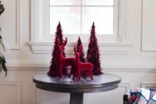 bold Christmas decor done with red feather trees and deer is easy to compose and looks very cool and chic