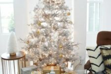 metallic decor ideas – a silver tree with gold and white ornaments and gift boxes wrapped with gold and silver