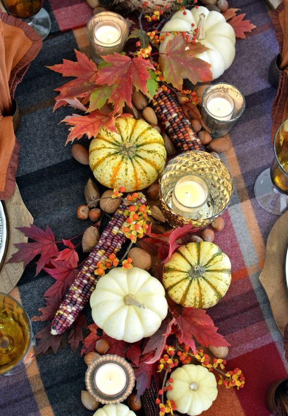rustic Thanksgiving decor of pumpkins, bold leaves, berries and corn cobs is lovely for fall, too
