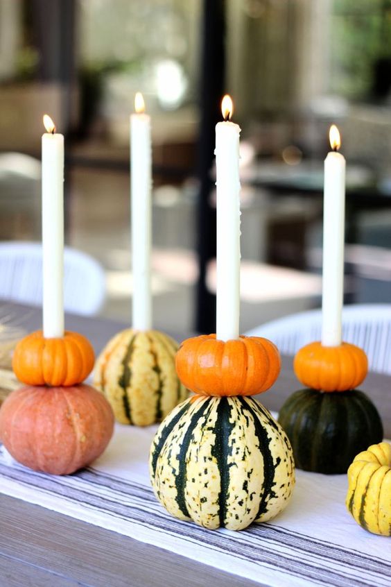 Stacked pumpkins with candles integrated are a very natural and very fall like idea of a Thanksgiving centerpiece that can be DIYed easily