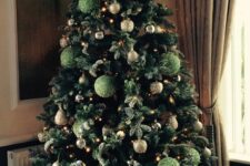 a Christmas tree decorated with green and gold glitter ornaments and lights is a super chic and glam idea