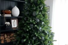 a Christmas tree decorated with only dark green plaid ribbon and nothing else is a very fresh and bold solution with a rustic feel