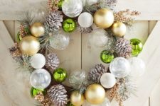 a Christmas wreath made of white and gild ornaments, snowy pinecones and snowy evergreens