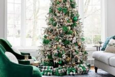 a beautiful flocked Christmas tree decorated with emerald and silver ornaments, emerald ribbons, lights and pinecone ornaments in gold