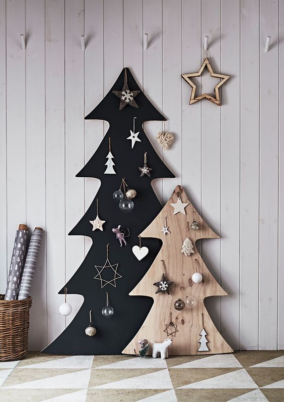 a black and stained plywood Christmas tree with ornaments are a cool idea for a Scandinavian space