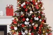 a bold traditional Christmas tree with red and white ornaments of various shapes, lights and with a red bow on top