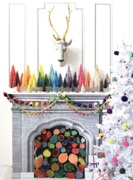 a bright Christmas mantel with colorful bottle cleaner Christmas trees, colorful pompom garlands and a tree with matching decor