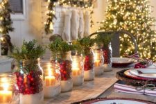 a cozy Christmas table with woven placemats, jars with faux snow, berries, greenery and candles and printed plates is bright and cool