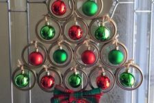 a creative Christmas tree of jar lids, green and red Christmas ornamerns and a plaid bow