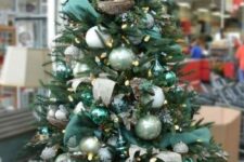 a dreamy Christmas tree with white and light green ornaments, dark green ribbons, acorns and lights plus faux birds in nests is wow