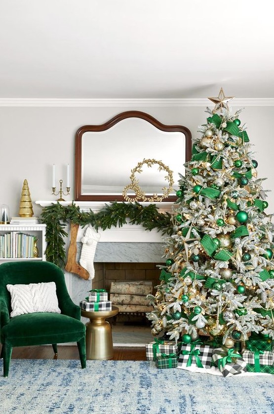 A fabulous Christmas space with an emeralf velvet chair, an evergreen pre lit garland, a flocked Christmas tree with emerald ribbons and ornaments, beads and lights