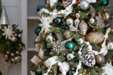 a fabulous Christmas tree with silver and metallic ornaments, bold grene ones, bead garlands, snowy pinecones and snowflakes