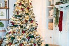 a flocked Christmas tree with lights, red and green ornaments and green ribbons is a very cute and chic idea