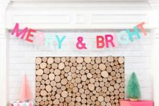 a non-traditional and bold Christmas mantel with large and small color block Christmas ornaments, a matching letter banner and gift boxes